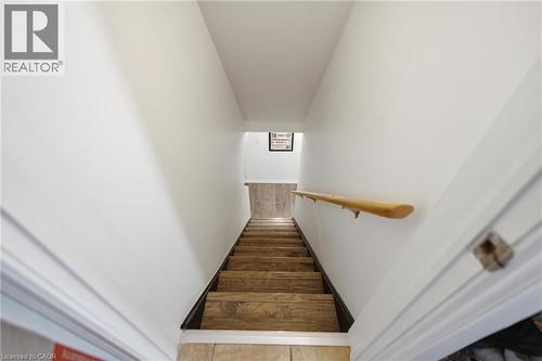 Stairs to basement featuring wood-finish treads, a light wood handrail, and white painted walls - 481 Upper Gage Avenue, Hamilton, ON - Indoor Photo Showing Other Room