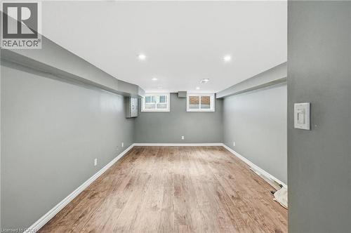 Finished living room with wood-finish flooring, recessed lighting, and two windows providing natural light - 481 Upper Gage Avenue, Hamilton, ON - Indoor Photo Showing Other Room
