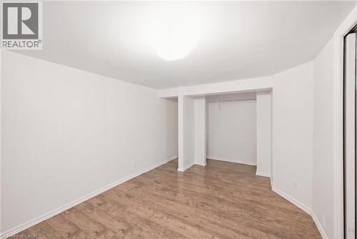Basement Bedroom featuring wood-finish flooring, white baseboards, and a large closet - 481 Upper Gage Avenue, Hamilton, ON - Indoor Photo Showing Other Room