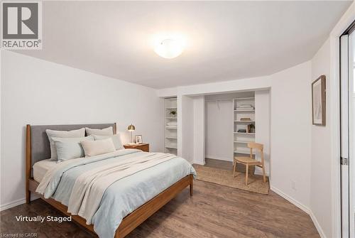 Basement Bedroom featuring wood-finish flooring, white baseboards, and a large closet - 481 Upper Gage Avenue, Hamilton, ON - Indoor Photo Showing Bedroom