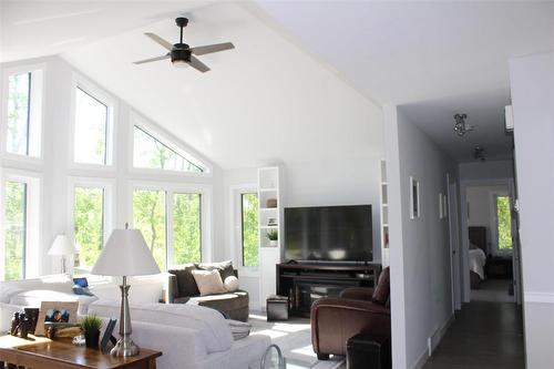 Stunning wall of windows allows for so much natural light. No need for blinds as the property is almost hidden from the road from all the trees. - 7 Dalvik Road, Gimli Rm, MB - Indoor Photo Showing Living Room