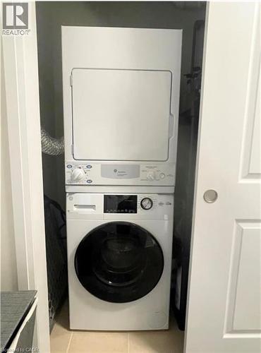 Stacked washer and dryer unit within an enclosed closet - 17 Visionary Avenue, Kitchener, ON - Indoor Photo Showing Laundry Room