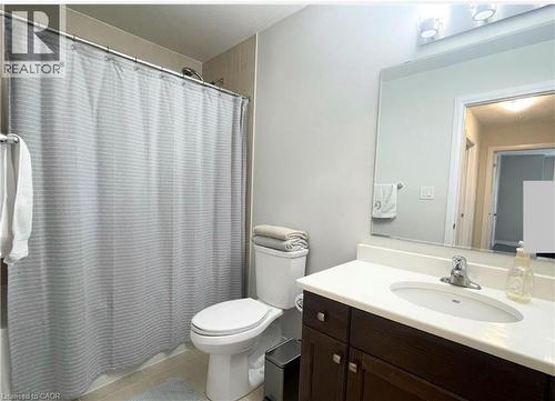 White vanity countertop with integrated sink, dark wood-finish cabinetry, and a chrome faucet - 17 Visionary Avenue, Kitchener, ON - Indoor Photo Showing Bathroom