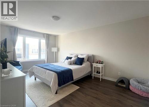 Wood-finish flooring, recessed lighting, expansive window with white trim, light neutral wall paint - 17 Visionary Avenue, Kitchener, ON - Indoor Photo Showing Bedroom