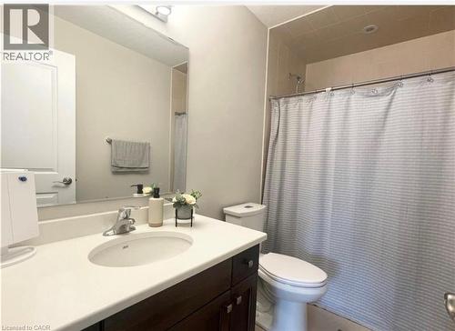 Vanity with a built-in sink and countertop, large wall-mounted mirror, and a shower with tiled surround - 17 Visionary Avenue, Kitchener, ON - Indoor Photo Showing Bathroom