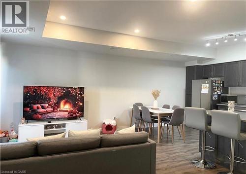 Recessed lighting, wood-finish flooring, dark-toned cabinetry, stainless steel refrigerator, and track lighting - 17 Visionary Avenue, Kitchener, ON - Indoor