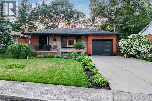 Brick and stone facade with a dark shingle roof - 24 Garvey Crescent, Hamilton, ON - Outdoor With Deck Patio Veranda With Facade