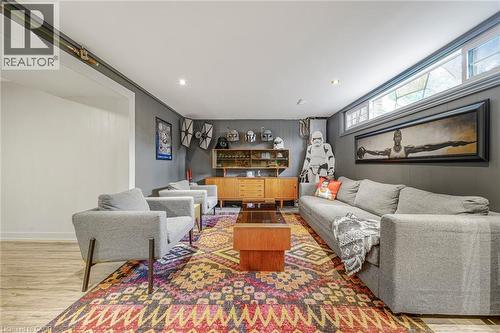 Recessed lighting, wood-finish flooring, and a built-in mid-century modern style cabinet with display shelving - 24 Garvey Crescent, Hamilton, ON - Indoor Photo Showing Living Room
