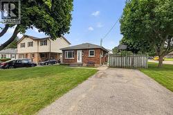Brick exterior with a white entry door, multiple windows, and a driveway - 