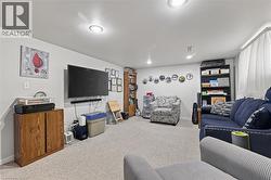 Carpeted interior space featuring recessed lighting and a wall-mounted television - 