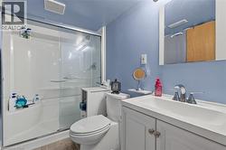 Bathroom featuring a white vanity with a single basin sink, chrome faucet, and mirrored medicine cabinet - 