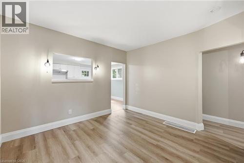 Bright, open living space featuring pristine wood-finish flooring, neutral wall finishes, and recessed ceiling lighting - 56 Harmony Avenue, Hamilton, ON - Indoor Photo Showing Other Room