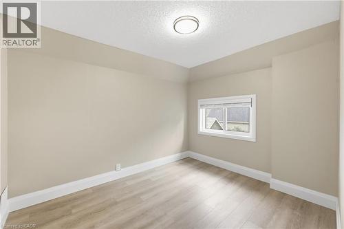 Recessed window with blinds, wood-finish flooring, and a flush-mount ceiling light - 56 Harmony Avenue, Hamilton, ON - Indoor Photo Showing Other Room