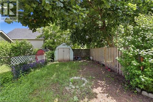 Rear yard featuring a garden shed, mature trees, and a privacy fence - 56 Harmony Avenue, Hamilton, ON - Outdoor