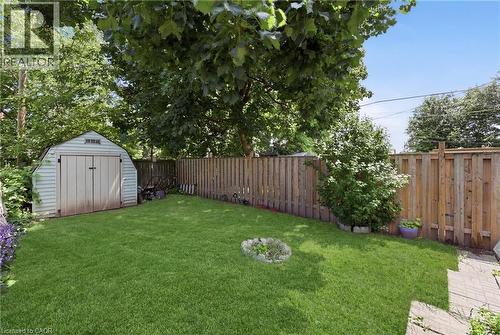 Expansive grassy yard with a storage shed, wood privacy fencing, and mature trees - 56 Harmony Avenue, Hamilton, ON - Outdoor