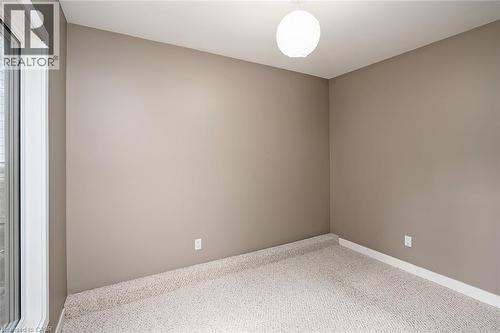 Neutral paint palette with light-colored carpeting, featuring a modern spherical ceiling light fixture - 4189 Inglewood Drive, Burlington, ON - Indoor Photo Showing Other Room