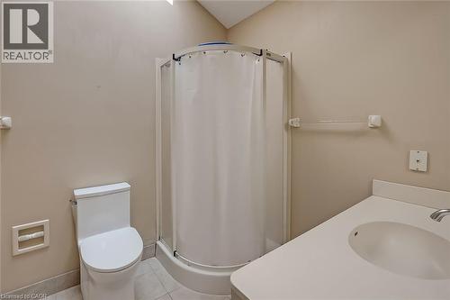 Compact three-fixture bathroom featuring a white toilet, corner shower enclosure, and a vanity with an integrated sink - 4189 Inglewood Drive, Burlington, ON - Indoor Photo Showing Bathroom