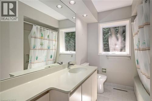 White vanity with integrated sink, chrome faucet, and expansive mirror - 4189 Inglewood Drive, Burlington, ON - Indoor Photo Showing Bathroom