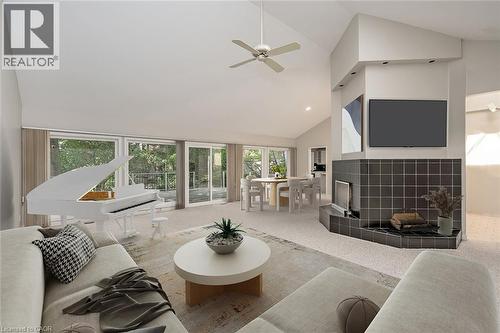 Vaulted ceiling with a ceiling fan, multiple sliding glass doors, and a tiled fireplace - 4189 Inglewood Drive, Burlington, ON - Indoor Photo Showing Living Room