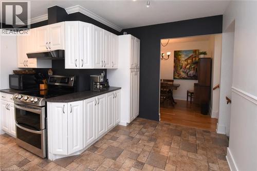 White cabinetry, stainless steel range, and tile flooring - 374 Brigadoon Drive, Hamilton, ON - Indoor Photo Showing Kitchen
