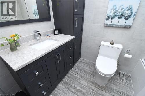 Modern vanity with a light-toned countertop, under-mount sink, and chrome faucet - 374 Brigadoon Drive, Hamilton, ON - Indoor Photo Showing Bathroom
