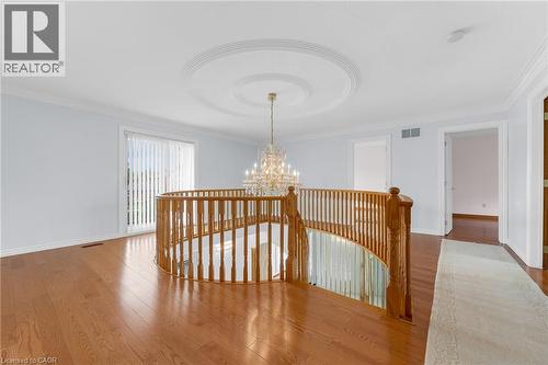 Hardwood flooring, curved wood balustrade, ceiling medallion, chandelier, and a sliding glass door - 35 Glen Park Court, Hamilton, ON - Indoor Photo Showing Other Room