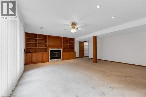 Integrated wood-tone built-in shelving with an electric fireplace, recessed lighting, and a ceiling fan - 35 Glen Park Court, Hamilton, ON - Indoor With Fireplace
