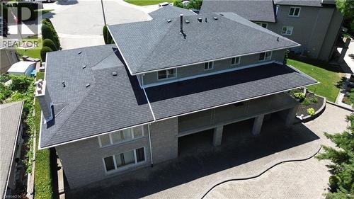 Asphalt shingle roof with multiple gables, brick exterior, and a covered patio with railing - 35 Glen Park Court, Hamilton, ON - Outdoor With Exterior
