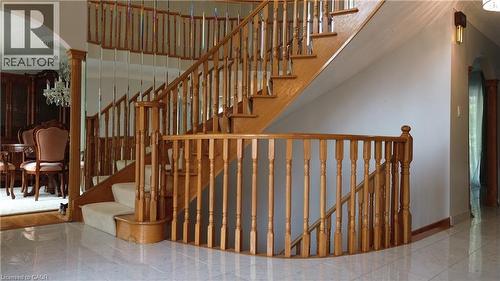 Grand wooden staircase with carpeted treads, featuring a curved banister and mirror accents - 35 Glen Park Court, Hamilton, ON - Indoor Photo Showing Other Room