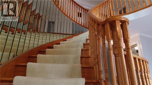 Curved staircase featuring wood balusters, wood handrail, and carpeted treads - 35 Glen Park Court, Hamilton, ON - Indoor Photo Showing Other Room