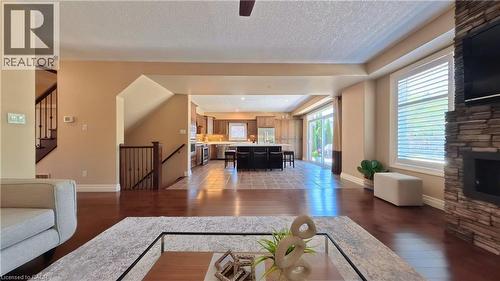 Hardwood-finish flooring throughout the living area - 913 Valebrook Court, Kitchener, ON - Indoor Photo Showing Living Room With Fireplace