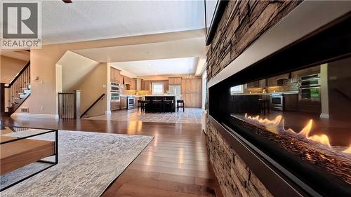 Open-concept living space featuring hardwood flooring throughout, a linear gas fireplace with brick surround, and abundant natural light - 913 Valebrook Court, Kitchener, ON - Indoor
