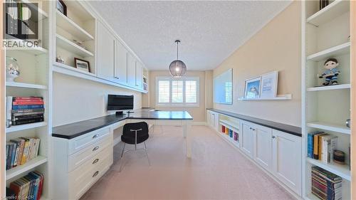 Sophisticated home office featuring dual built-in cabinetry with open shelving and closed storage, quartz countertops, and ample natural light from multi-pane windows - 913 Valebrook Court, Kitchener, ON - Indoor