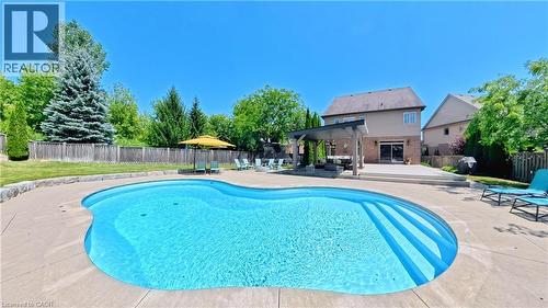 Freeform swimming pool with integrated steps, surrounded by a concrete patio - 913 Valebrook Court, Kitchener, ON - Outdoor With In Ground Pool With Deck Patio Veranda With Backyard