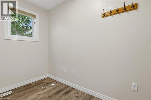 Bright, light-filled room with wood-finish flooring, white painted walls, and large window with natural light - 43 Decaro Crescent, Cambridge, ON - Indoor Photo Showing Other Room