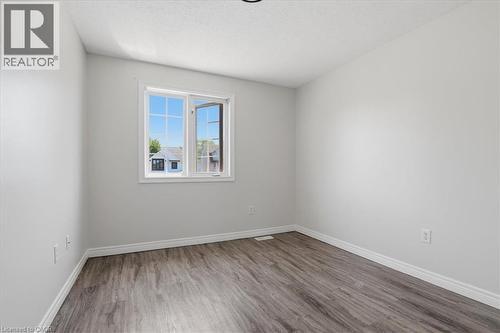 Neutral wall paint, wood-finish flooring, and a double-pane window - 43 Decaro Crescent, Cambridge, ON - Indoor Photo Showing Other Room