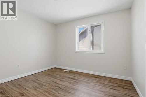 Wood-finish flooring, white trim, and a white-framed window - 43 Decaro Crescent, Cambridge, ON - Indoor Photo Showing Other Room