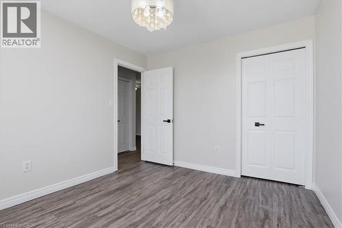 Bright bedroom featuring gleaming wood-finish flooring, multiple closet spaces with six-panel doors, and a recessed ceiling fixture - 43 Decaro Crescent, Cambridge, ON - Indoor Photo Showing Other Room