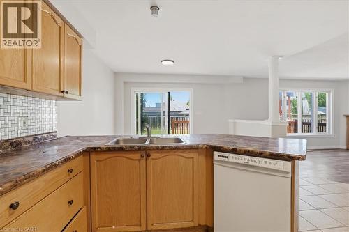 Kitchen featuring wood cabinetry, a double basin sink, and a mosaic tile backsplash - 43 Decaro Crescent, Cambridge, ON - Indoor Photo Showing Kitchen With Double Sink