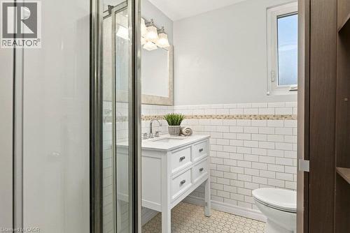 Spa-inspired bathroom featuring a walk-in shower enclosure with brushed nickel framing, white subway tile walls with decorative tile trim, a white vanity with multiple drawers and chrome hardware, pol - 23 Kipling Road, Hamilton, ON - Indoor Photo Showing Bathroom