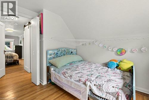 Bright bedroom featuring wood-finish flooring, sloped vaulted ceilings, and ample natural light from recessed fixtures - 23 Kipling Road, Hamilton, ON - Indoor Photo Showing Bedroom