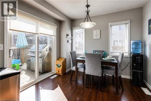 Dining area featuring wood-finish flooring, a contemporary chandelier, and a sliding glass door opening to a deck - 750 Lawrence Street Unit# 86, Cambridge, ON - Indoor Photo Showing Dining Room