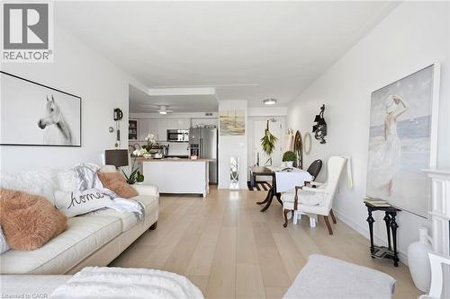 Open-concept living area featuring light wood-finish flooring, white walls, and recessed lighting - 8 Woodman Drive S Unit# 708, Hamilton, ON - Indoor Photo Showing Living Room