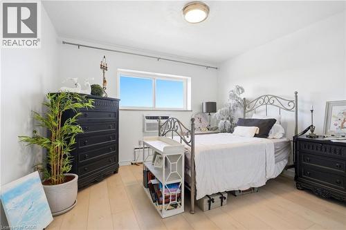Light-toned wood-finish flooring, white walls, and a prominent window - 8 Woodman Drive S Unit# 708, Hamilton, ON - Indoor Photo Showing Bedroom