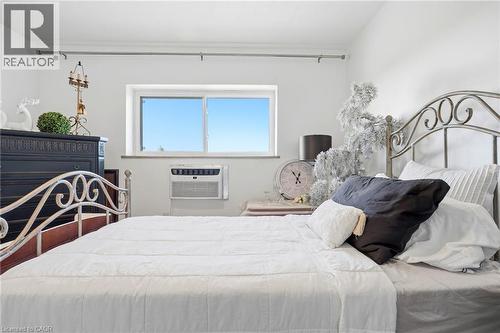 White painted walls with a window and a wall-mounted air conditioning unit - 8 Woodman Drive S Unit# 708, Hamilton, ON - Indoor Photo Showing Bedroom