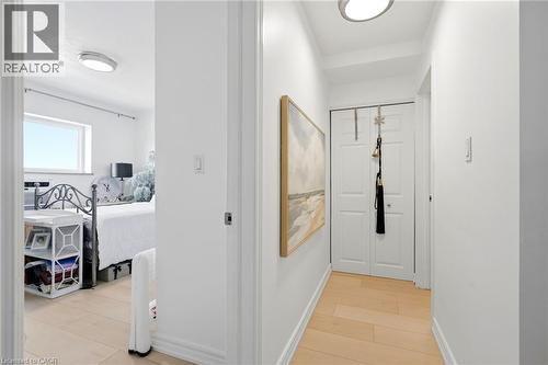 Hardwood-style flooring throughout, white interior doors, and modern flush-mount lighting fixtures - 8 Woodman Drive S Unit# 708, Hamilton, ON - Indoor Photo Showing Other Room