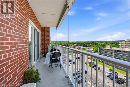 Private balcony with a sliding glass door, white railing, and red brick exterior - 8 Woodman Drive S Unit# 708, Hamilton, ON - Outdoor With Balcony With Exterior
