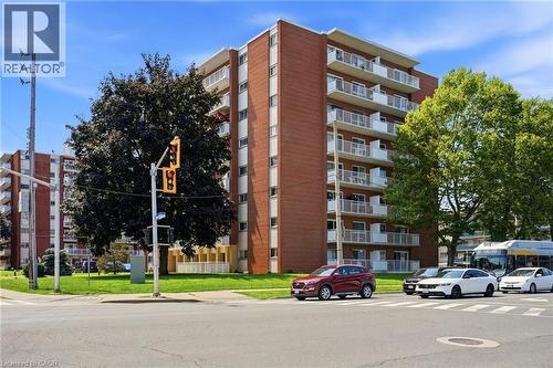 Multi-story residential building featuring brick exterior construction and numerous private balconies - 8 Woodman Drive S Unit# 708, Hamilton, ON - Outdoor With Balcony With Facade