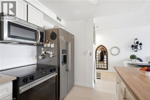 Kitchen featuring stainless steel appliances, including an over-the-range microwave, range, and refrigerator - 8 Woodman Drive S Unit# 708, Hamilton, ON - Indoor Photo Showing Kitchen