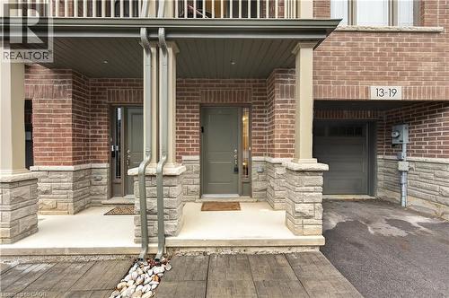 Brick and stone exterior with covered front porch, integrated garage, and a wood-finish pathway - 19 Picardy Drive Unit# 13, Hamilton, ON - Outdoor